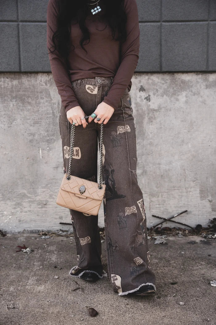 Dark wash wide-leg jeans with distressed cowboy graphic print, front view