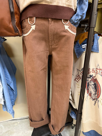 Brown straight-leg jeans with white-trim pockets and cream smiley details