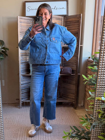 Blue denim jacket with button front, chest pockets, and long sleeves
