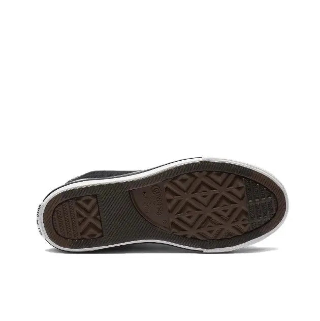 Black canvas sneaker outsole with textured tread and white midsole edge.