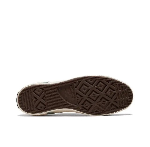 Low-top sneakers sole view with dark rubber tread and signature pattern