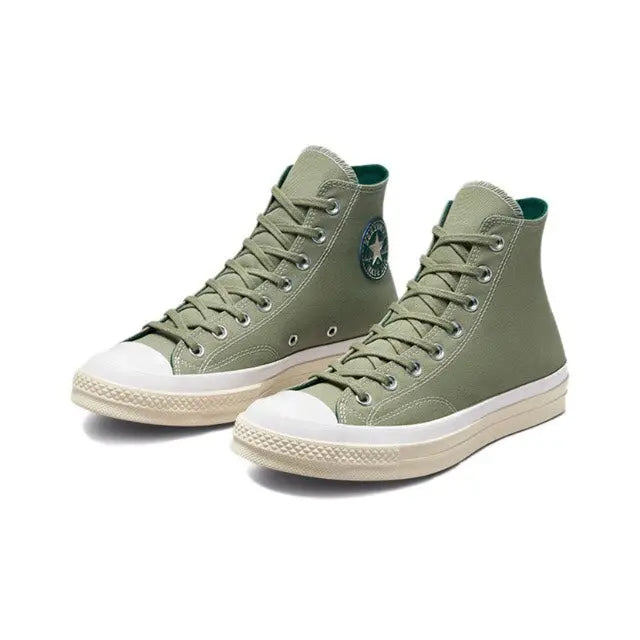Olive green high-top canvas sneakers with laces, side logo patch, and white sole