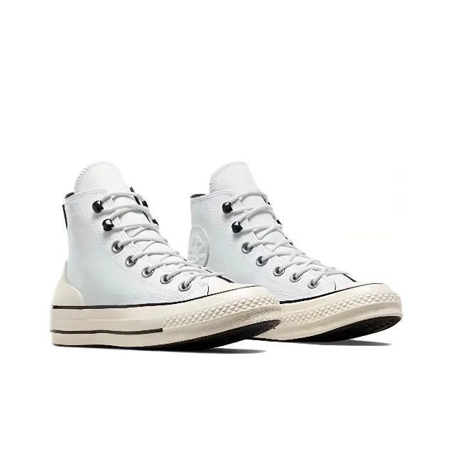 Light blue high-top sneakers with black laces, cream sole, circular side logo