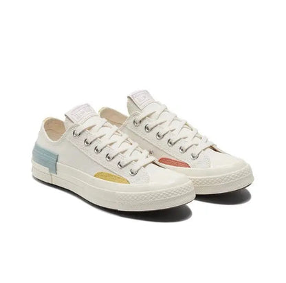 Low-top sneakers front view pair, white canvas with yellow, orange, and blue accents