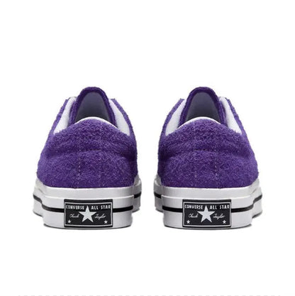 Purple low-top sneakers with white rubber toe caps and heel branding patch
