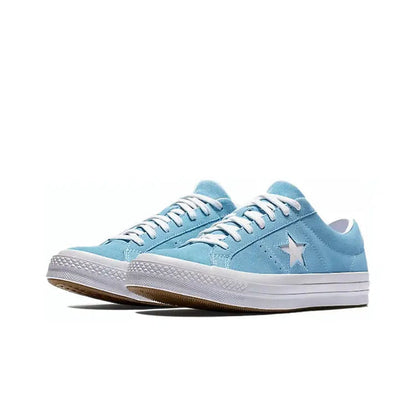 Light blue low-top sneakers with lace-up front, star emblem, and white sole