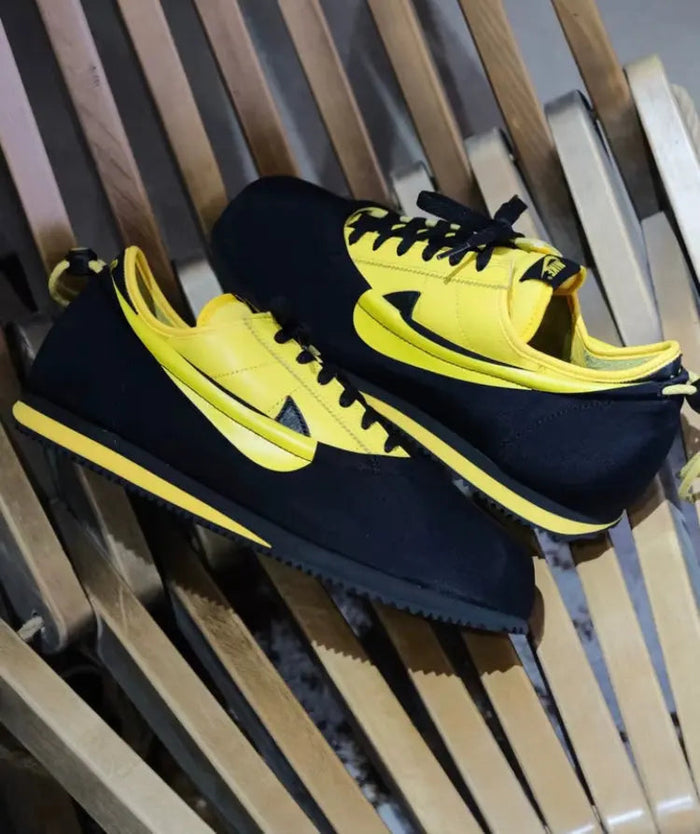 Low-top sneakers side view, black and yellow, yellow Swoosh detailing