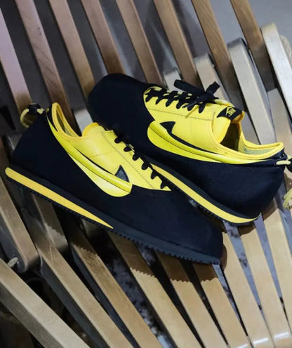 Low-top sneakers side view, black and yellow, yellow Swoosh detailing