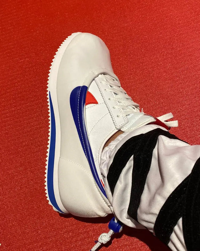 Nike Cortez x Clot sneakers close-up, white leather with blue trim and red tongue label