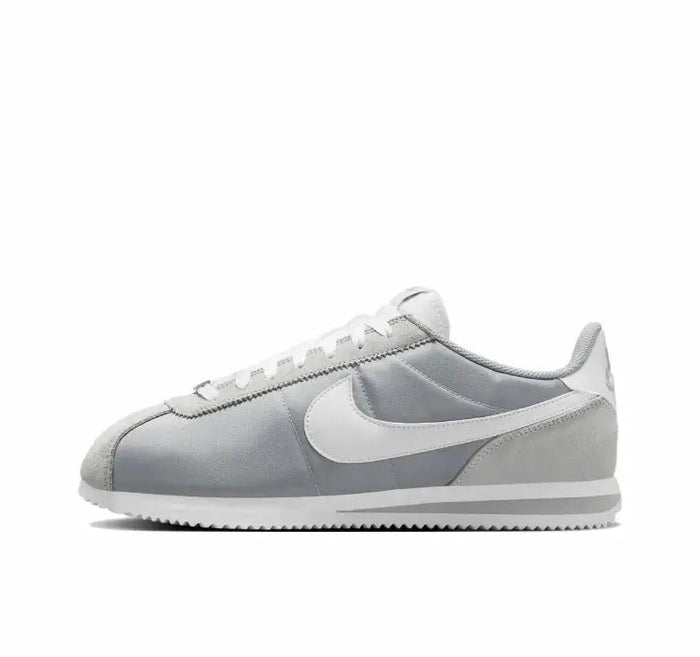 Nike low-top sneakers in light gray with white swoosh and pale blue accents