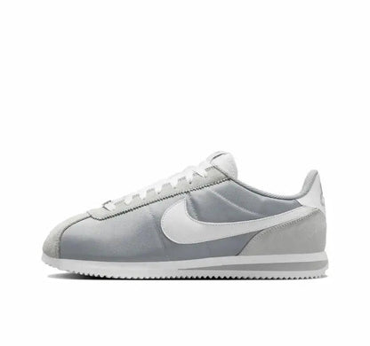 Nike low-top sneakers in light gray with white swoosh and pale blue accents