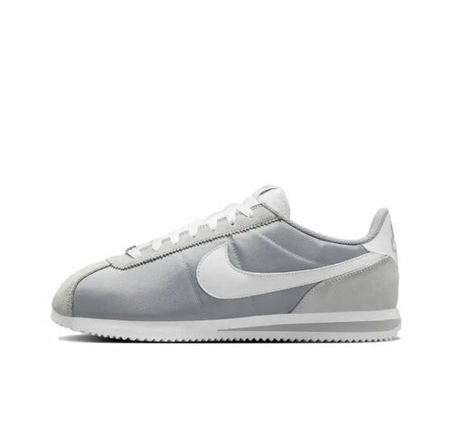Nike low-top sneakers in light gray with white swoosh and pale blue accents