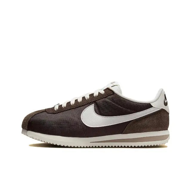 Nike Cortez sneakers in dark brown with white Swoosh and white midsole, lace-up.