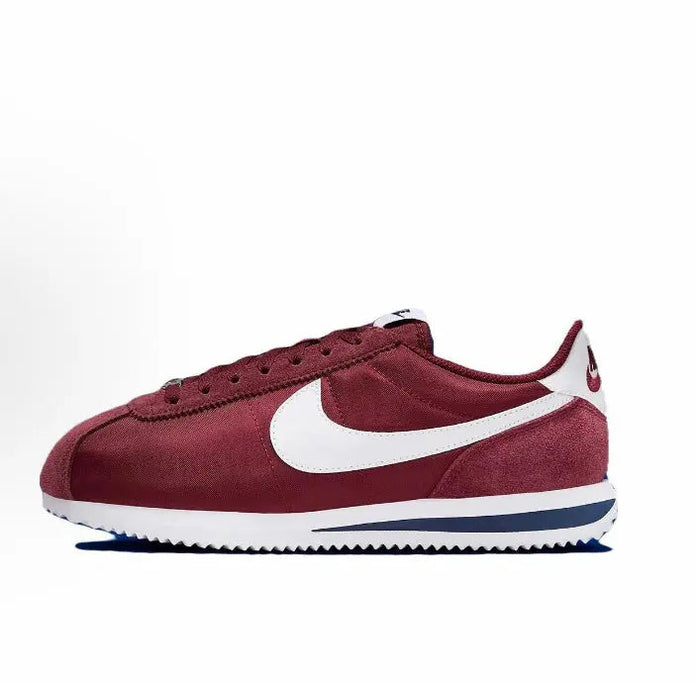 Wine red Cortez sneakers with white swoosh and blue-striped sole, lace-up low top