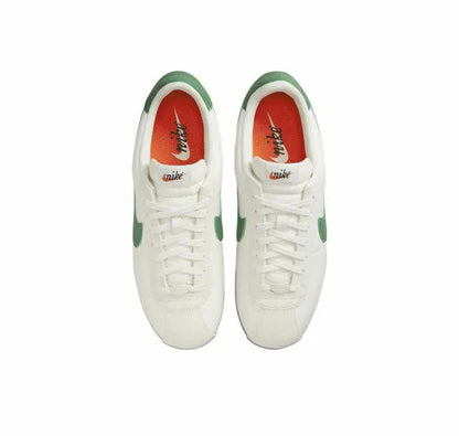 Low-top sneakers pair with white laces, red/orange inner lining, green accents