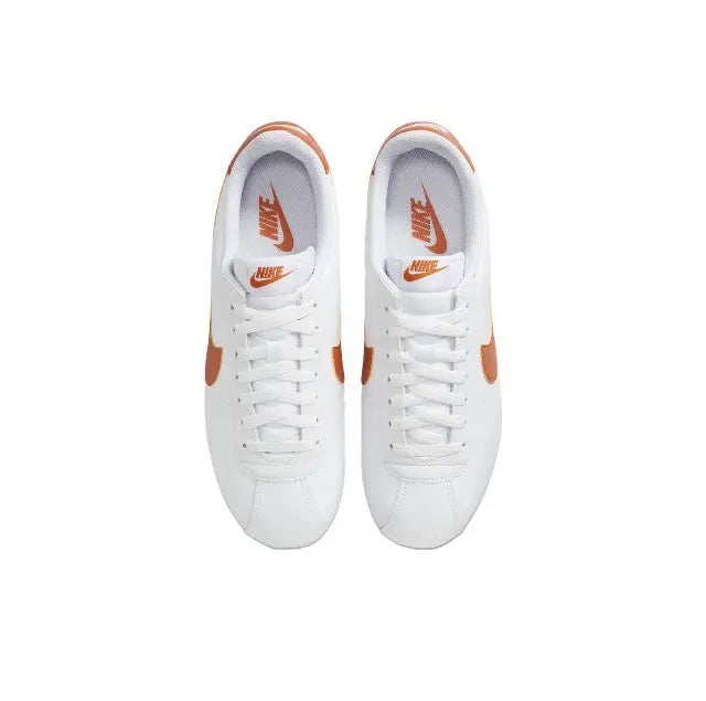 Cortez sneakers, pair view: white uppers with orange heel accents and laces