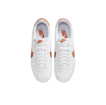 Cortez sneakers, pair view: white uppers with orange heel accents and laces