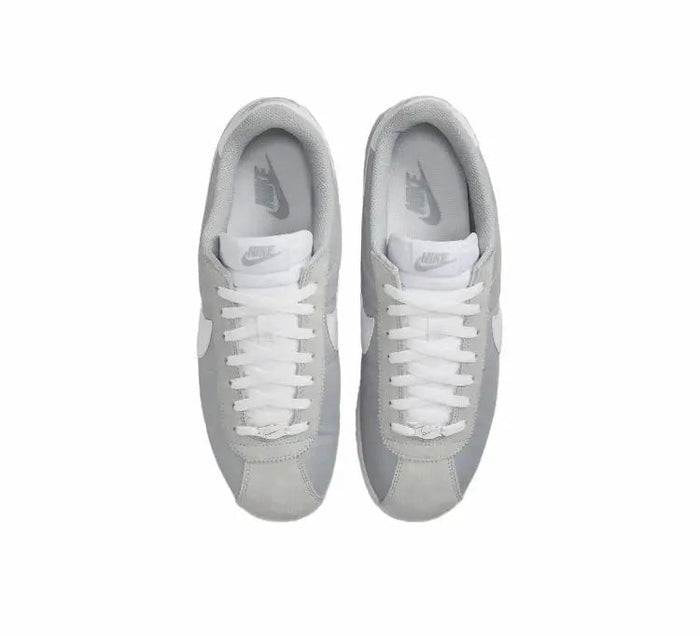 Pair of Nike low-top sneakers, white laces on light gray uppers