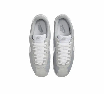 Pair of Nike low-top sneakers, white laces on light gray uppers