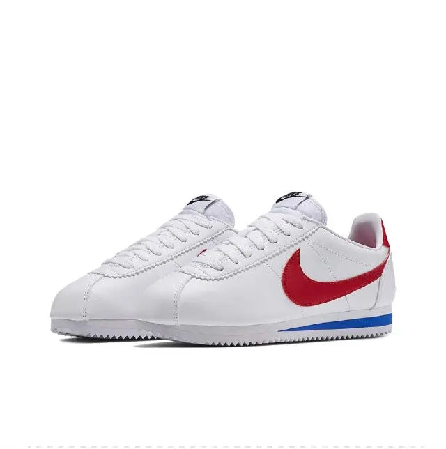 White Nike Cortez sneakers, two-quarter view, red swoosh and blue outsole stripe