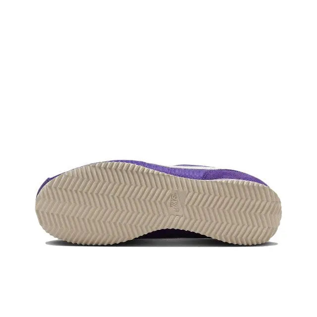 Purple low-top sneaker outsole with zigzag tread and striped midsole