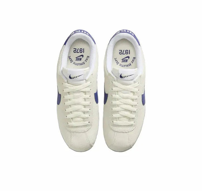Cortez sneakers, off-white uppers with blue heel accents, front view