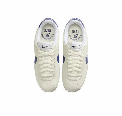 Cortez sneakers, off-white uppers with blue heel accents, front view