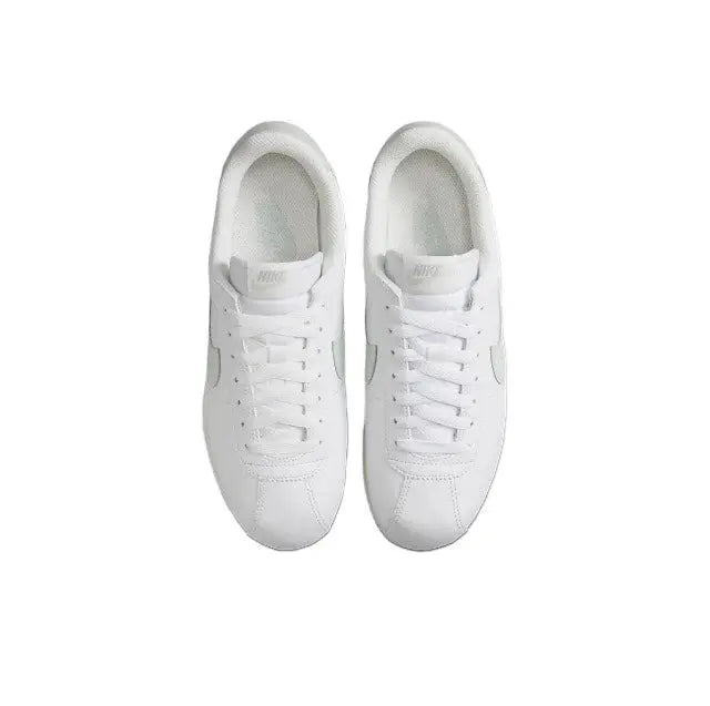 White low-top sneakers shown from the front with lace-up closure