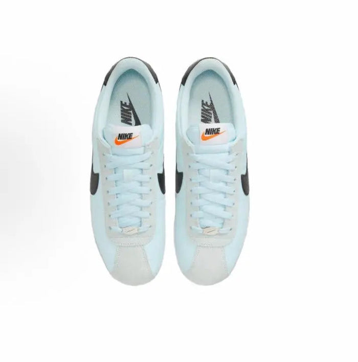 Light blue low-top sneakers, lace-up front view with black Swoosh