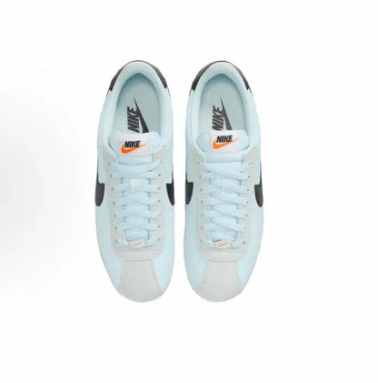Light blue low-top sneakers, lace-up front view with black Swoosh