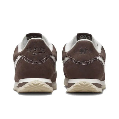 Brown low-top sneakers with white heel stripe and back pull-tab