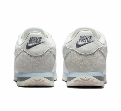 White low-top sneakers with NIKE heel logo and cushioned back