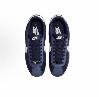 Pair of dark blue Nike sneakers with white heel tabs and navy lace-up uppers