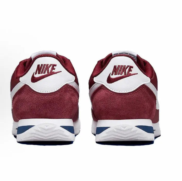 Back view of wine red sneakers with white Nike heel tab and blue stripe midsole