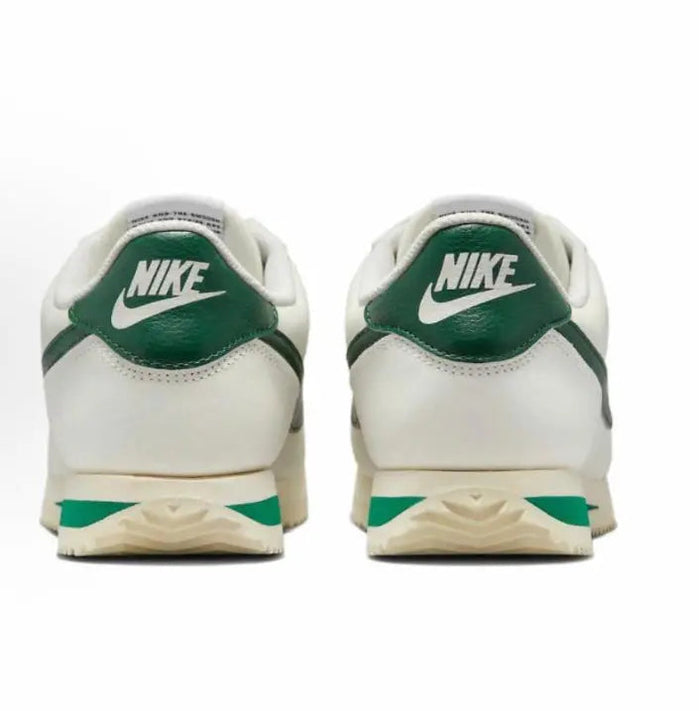 Cortez sneakers heel view in white with green Nike logo and striped midsole