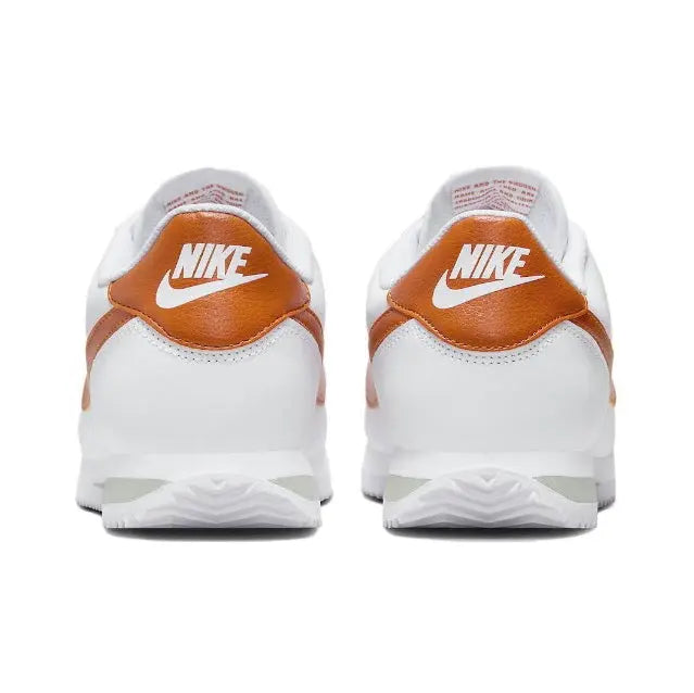 Cortez sneakers, back view: white leather with orange heel collar and Nike logo