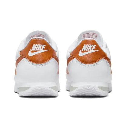 Cortez sneakers, back view: white leather with orange heel collar and Nike logo