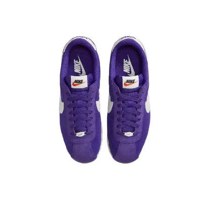 Pair of purple low-top sneakers with white swoosh logos and lace-ups