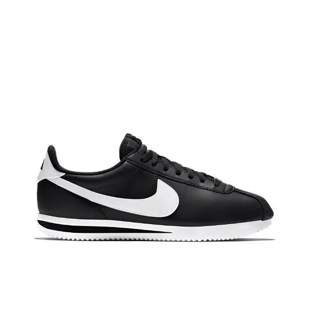 Black low-top sneaker side view with white swoosh and ribbed outsole