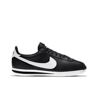 Black low-top sneaker side view with white swoosh and ribbed outsole