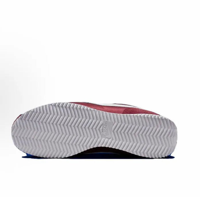 Wine red low-top sneaker outsole with zigzag tread and blue accent edge