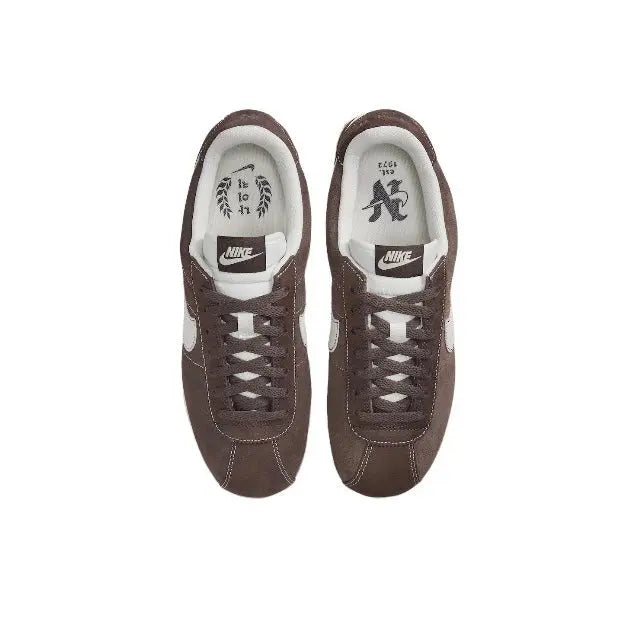 Brown low-top sneakers with white inner lining and lace-up eyelets