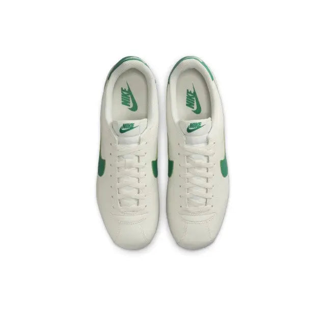 Low-top sneakers pair, white uppers with green heel and lace area