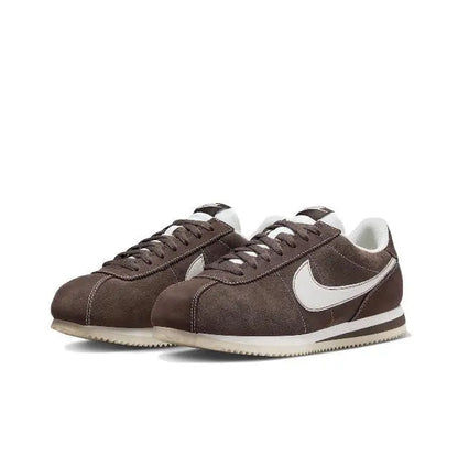 Brown low-top sneakers with white swoosh, laces, and striped midsole