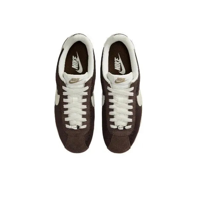 Nike Cortez sneakers with white laces, dark brown uppers, Nike tongue tag visible.