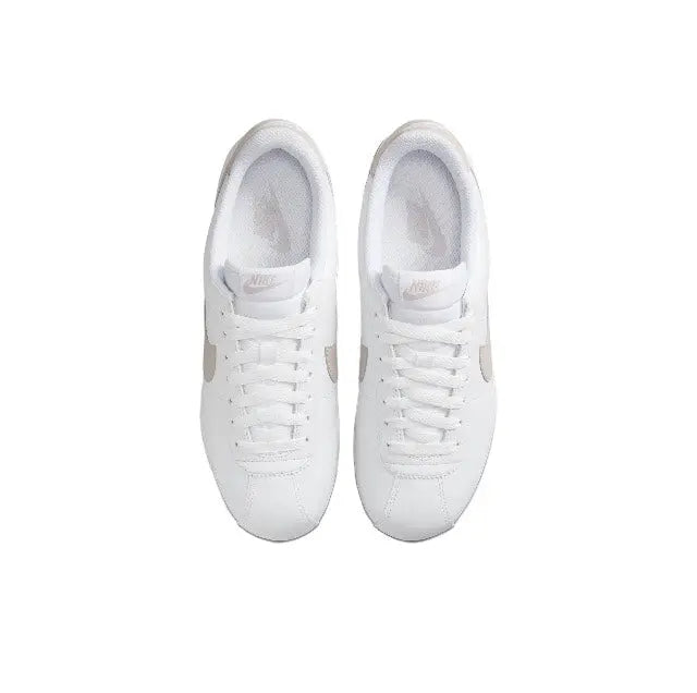Low-top sneakers side view with white laces and smooth white leather uppers