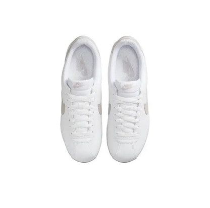 Low-top sneakers side view with white laces and smooth white leather uppers