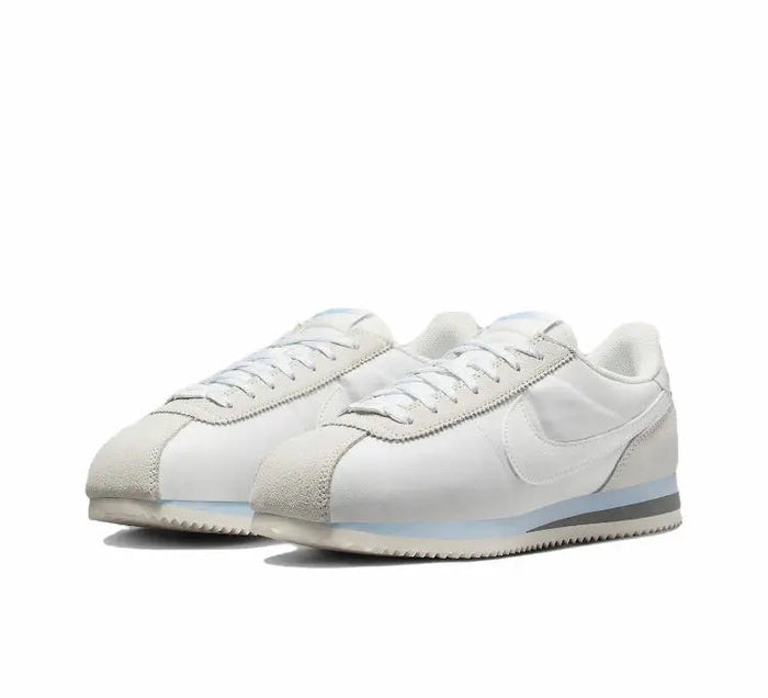 White low-top sneakers with side swoosh and textured toe panel