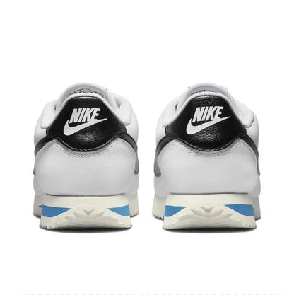 Nike Cortez sneakers, white uppers with black heel Nike badge and blue midsole stripe