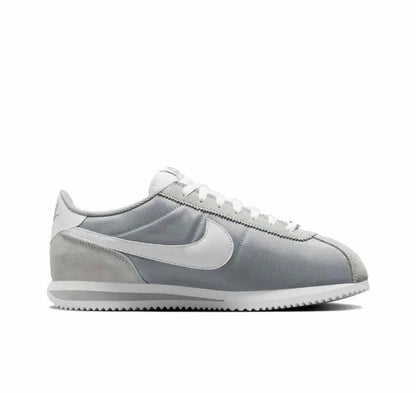 Nike low-top sneakers side view, light gray upper with white swoosh and pale blue trim